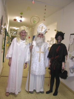 Saint Nicholas coming accompanied by an angel and a devil.